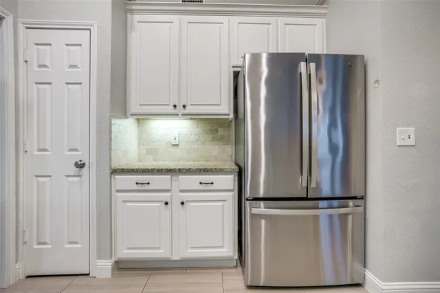 a kitchen with cabinets and a refrigerator