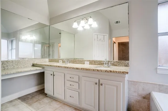 a bathroom with a granite countertop sink two mirror and a