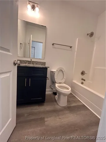 a spacious bathroom with a granite countertop toilet sink and mirror