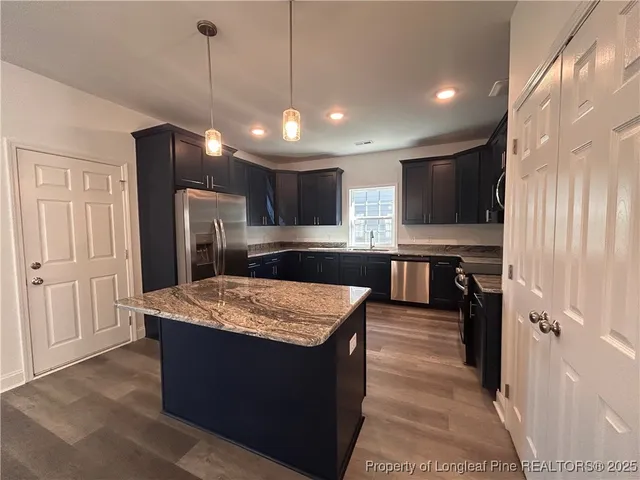 a large kitchen with kitchen island a sink stainless steel appliances and cabinets