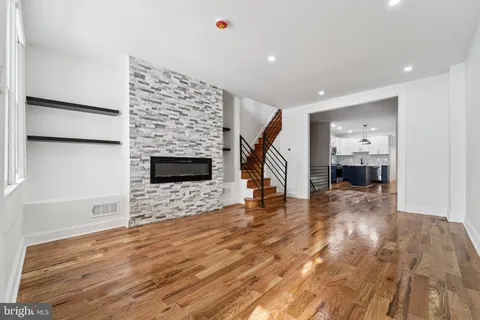 a view of empty room with wooden floor and stairs