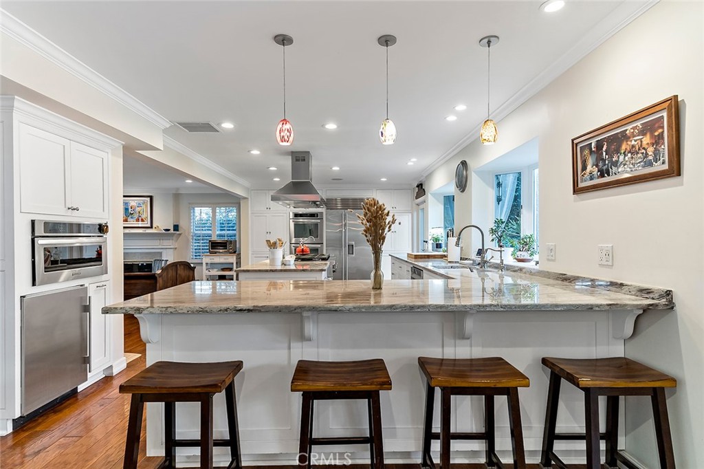 11792 Silver Fox Road Rossmoor, CA 90720 - Photo 10 of 49 a kitchen with stainless steel appliances granite countertop a dining table chairs stove and white cabinets