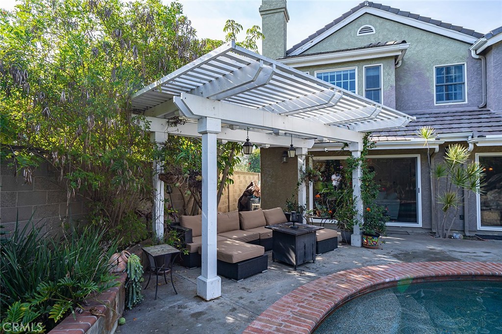11792 Silver Fox Road Rossmoor, CA 90720 - Photo 18 of 49 a view of a patio with table and chairs potted plants and floor to ceiling window