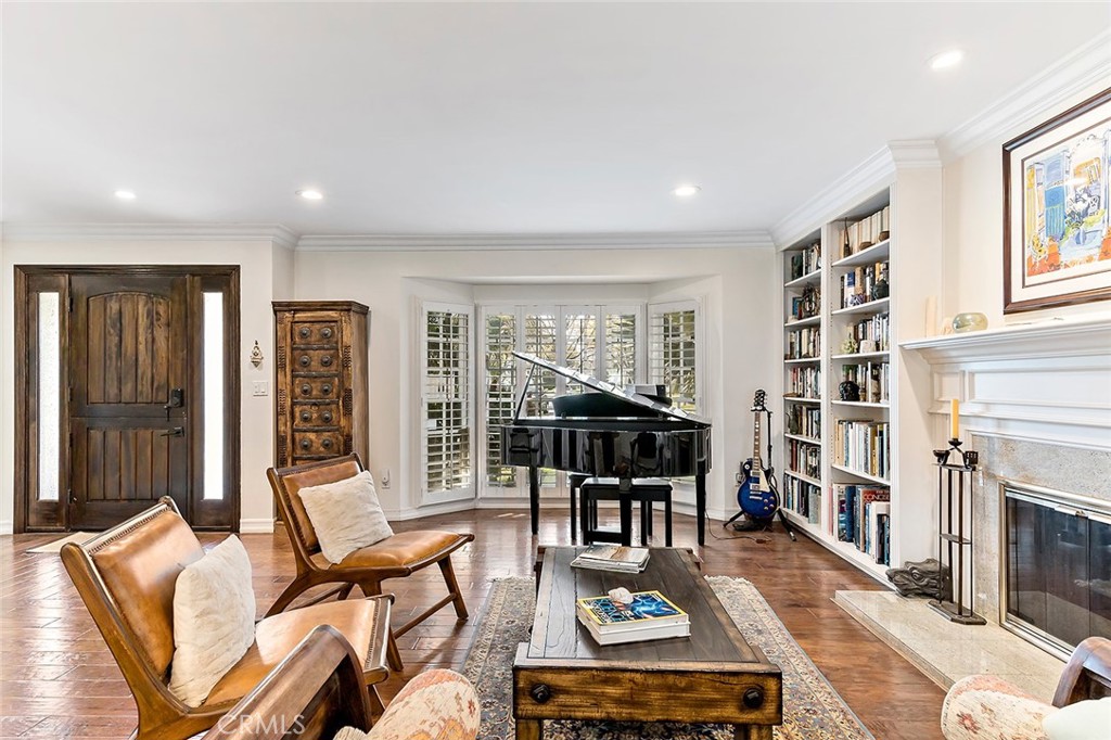 11792 Silver Fox Road Rossmoor, CA 90720 - Photo 3 of 49 a living room with furniture a fireplace and a book shelf