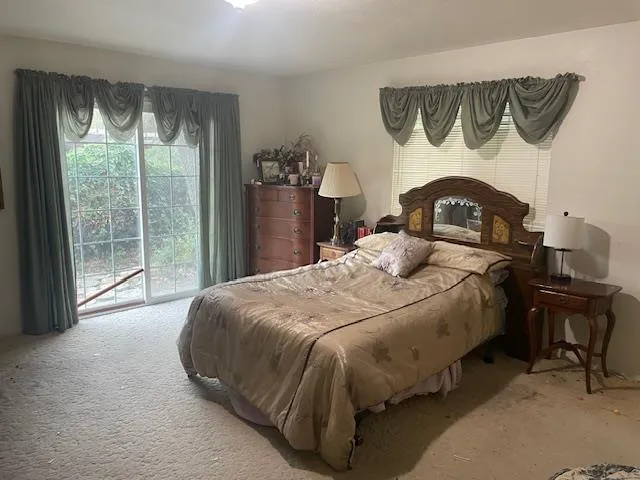 a bedroom with a bed and a large window with the outer view