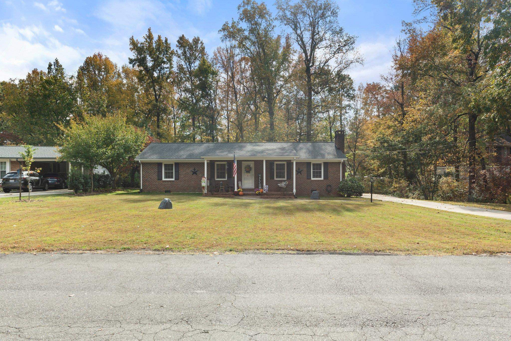 1818 Wellington Road Burlington, NC 27217 - Photo 31 of 36 a front view of a house with swimming pool and trees in the background