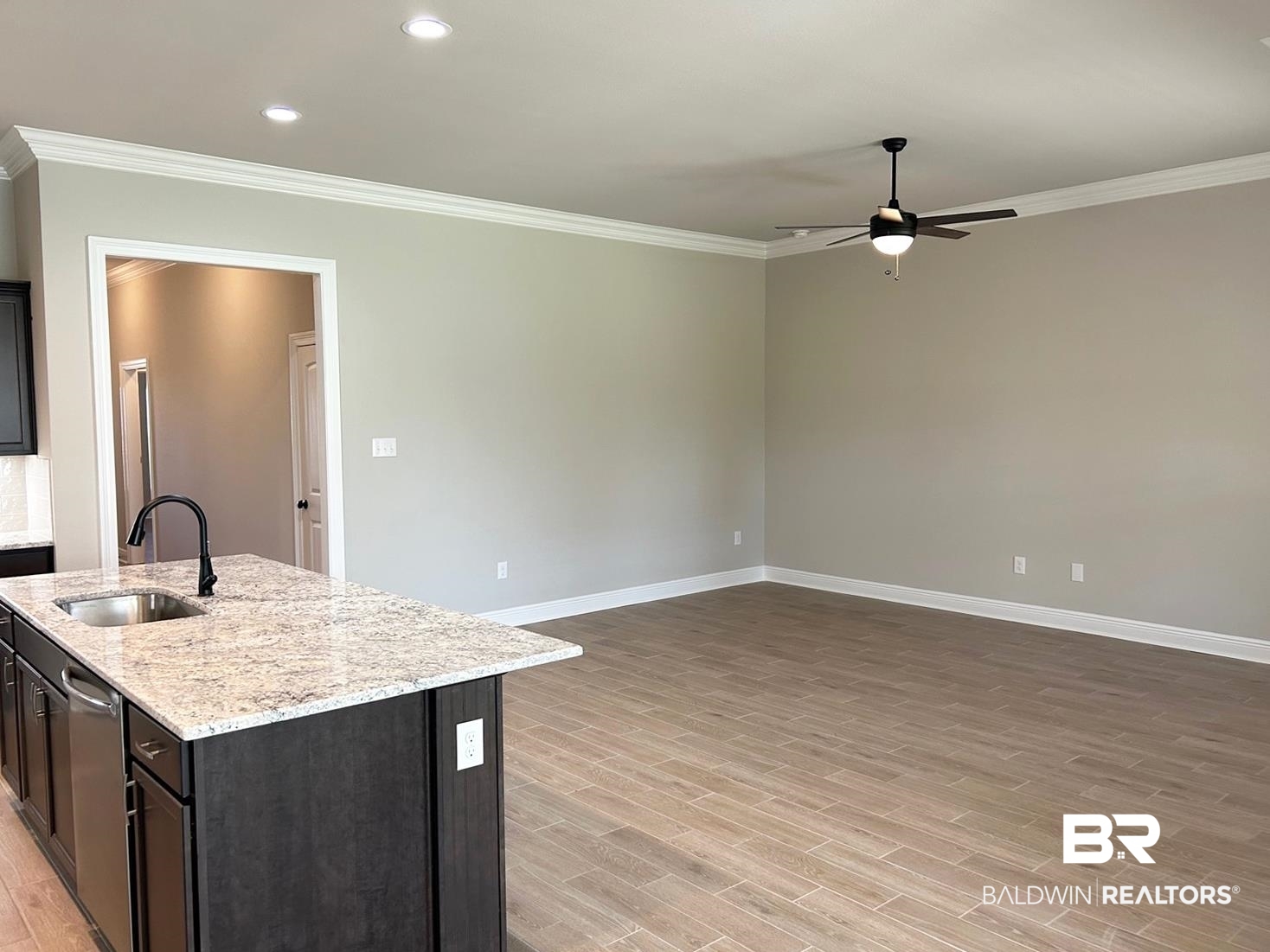848 Sumter Loop Foley, AL 36535 - Photo 4 of 16 Kitchen featuring a center island with sink, sink, crown molding, light hardwood / wood-style floors, and ceiling fan