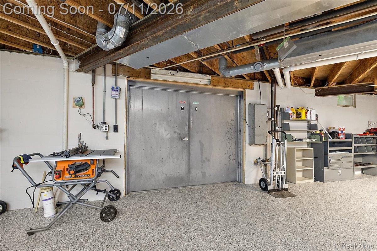 4219 Gardner Road Metamora, MI 48455 - Photo 58 of 87 Utility space featuring a durable speckled epoxy floor, exposed ceiling joists, and a metal double door