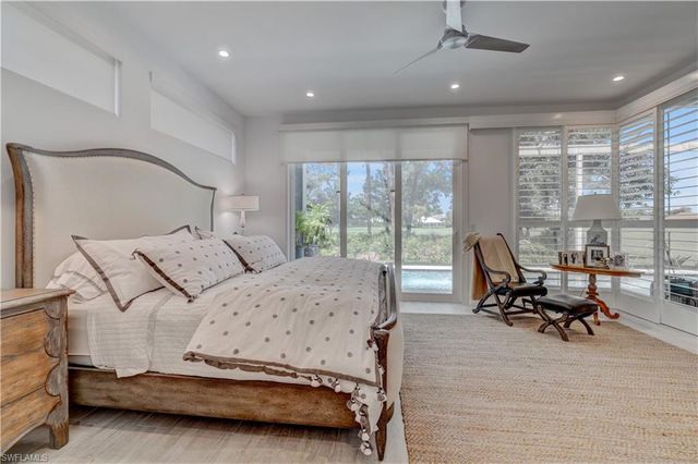 a bedroom with furniture and large windows