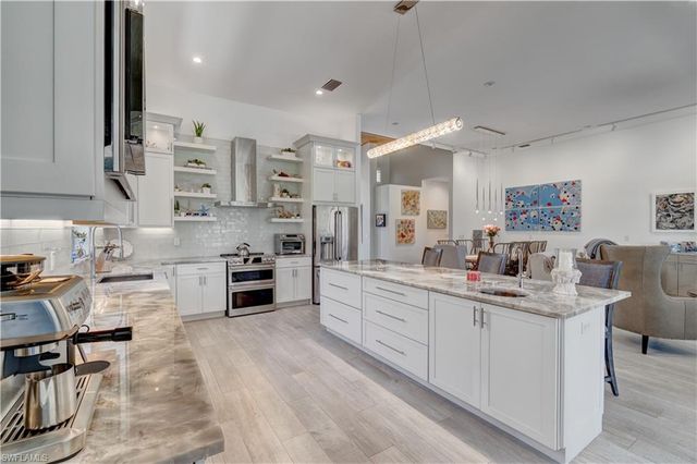 a kitchen with stainless steel appliances kitchen island granite countertop a sink and cabinets