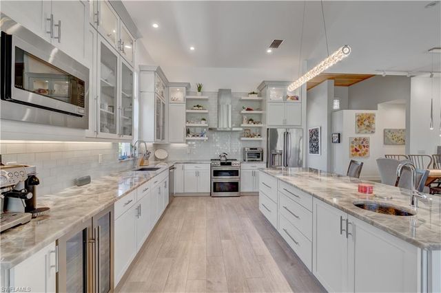 a large kitchen with stainless steel appliances lots of counter space and a sink