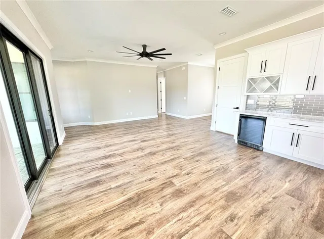 a view of a kitchen with wooden floor and a ceiling fan