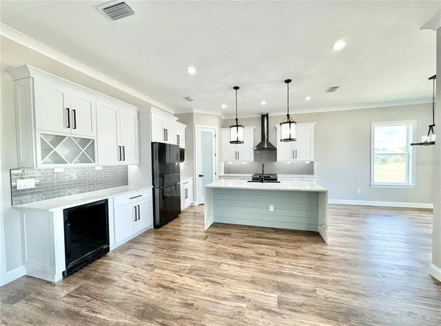 a view of kitchen with granite countertop cabinets and refrigerator