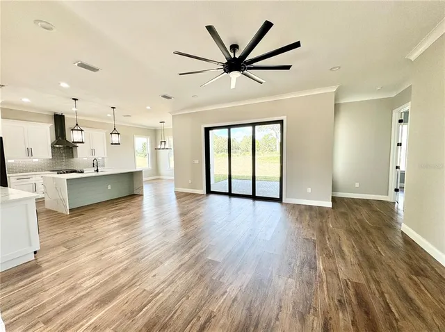 a view of a kitchen with a wooden floor and a ceiling fan