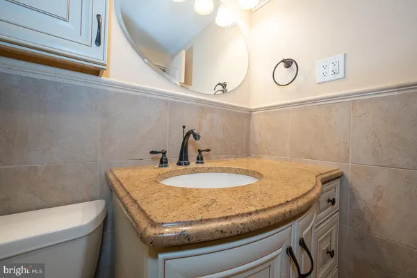 a bathroom with a granite countertop sink a toilet and a shower