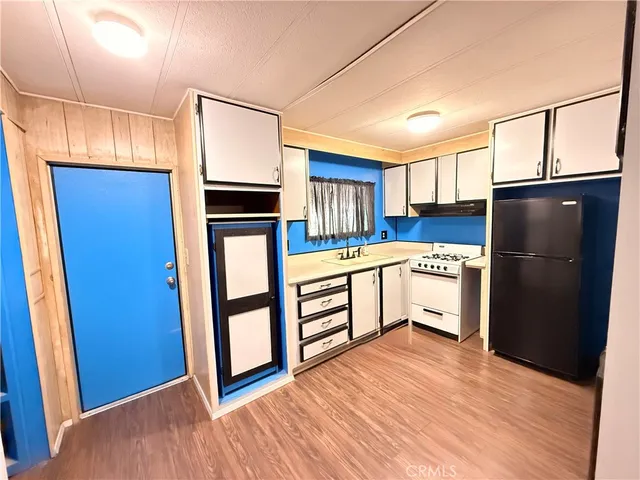a kitchen with stainless steel appliances a refrigerator and wooden floor