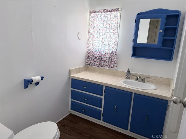 a bathroom with a toilet a sink and mirror