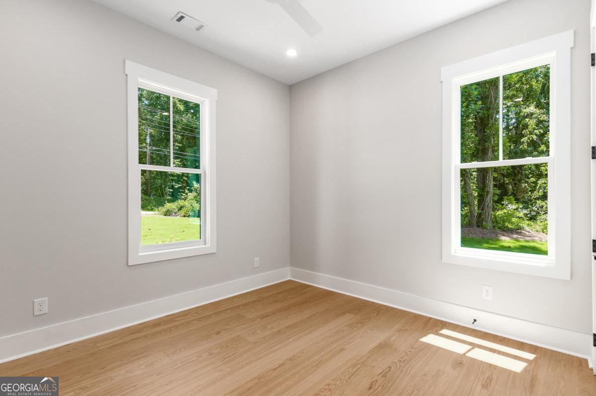 229 Eagles Way Eatonton, GA 31024 - Photo 21 of 61 an empty room with wooden floor and windows