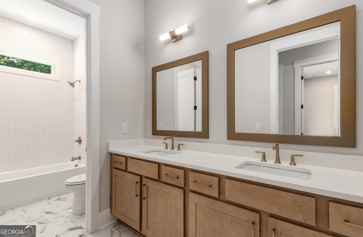 229 Eagles Way Eatonton, GA 31024 - Photo 22 of 61 a bathroom with a sink double vanity and a bathtub