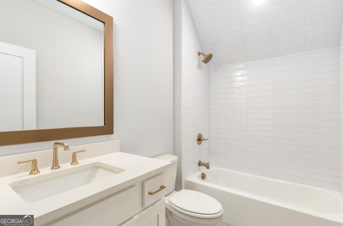 229 Eagles Way Eatonton, GA 31024 - Photo 34 of 61 a bathroom with a granite countertop sink toilet a mirror and shower