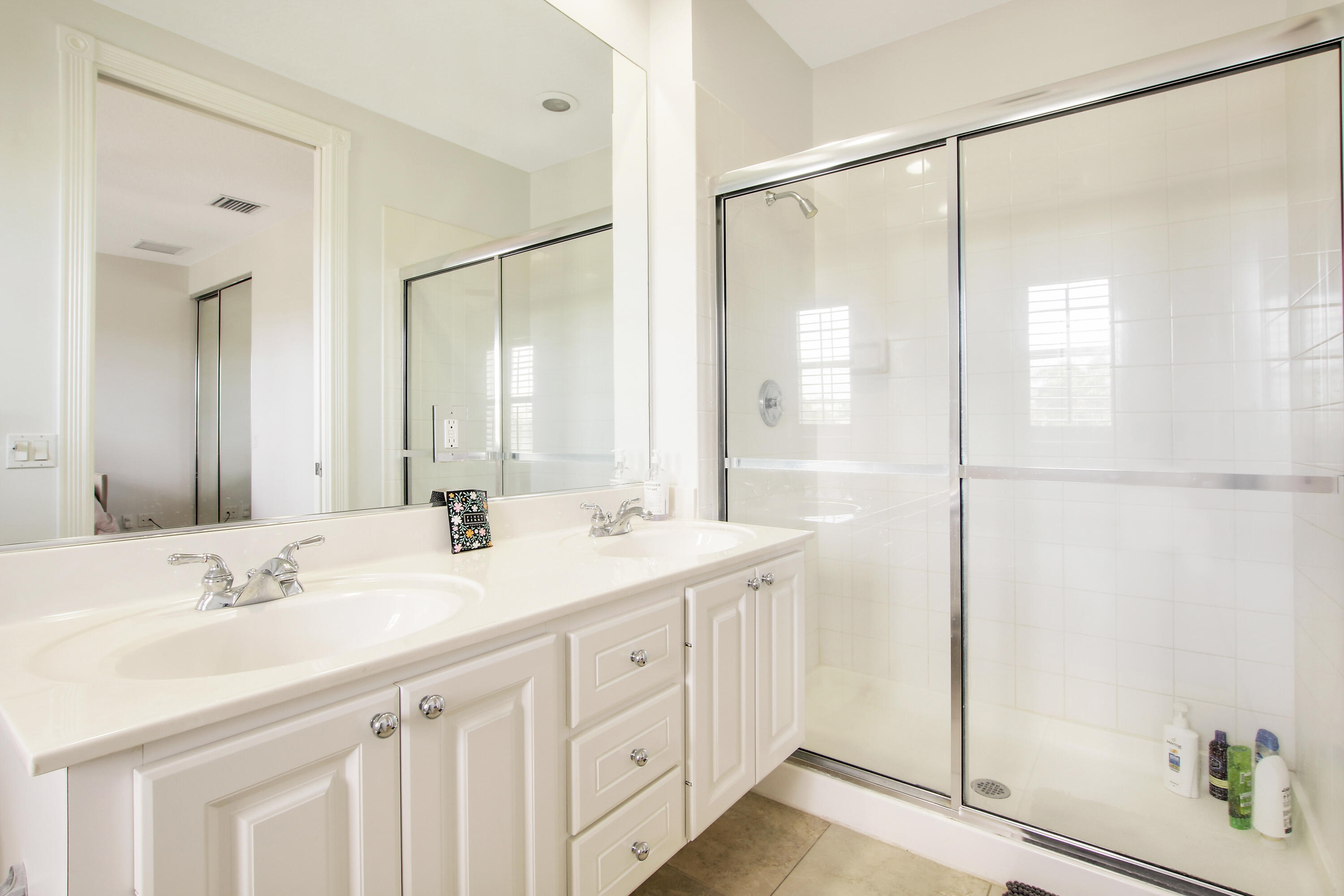 3424 West Community Drive Jupiter, FL 33458 - Photo 18 of 25 a bathroom with a double vanity sink mirror and shower