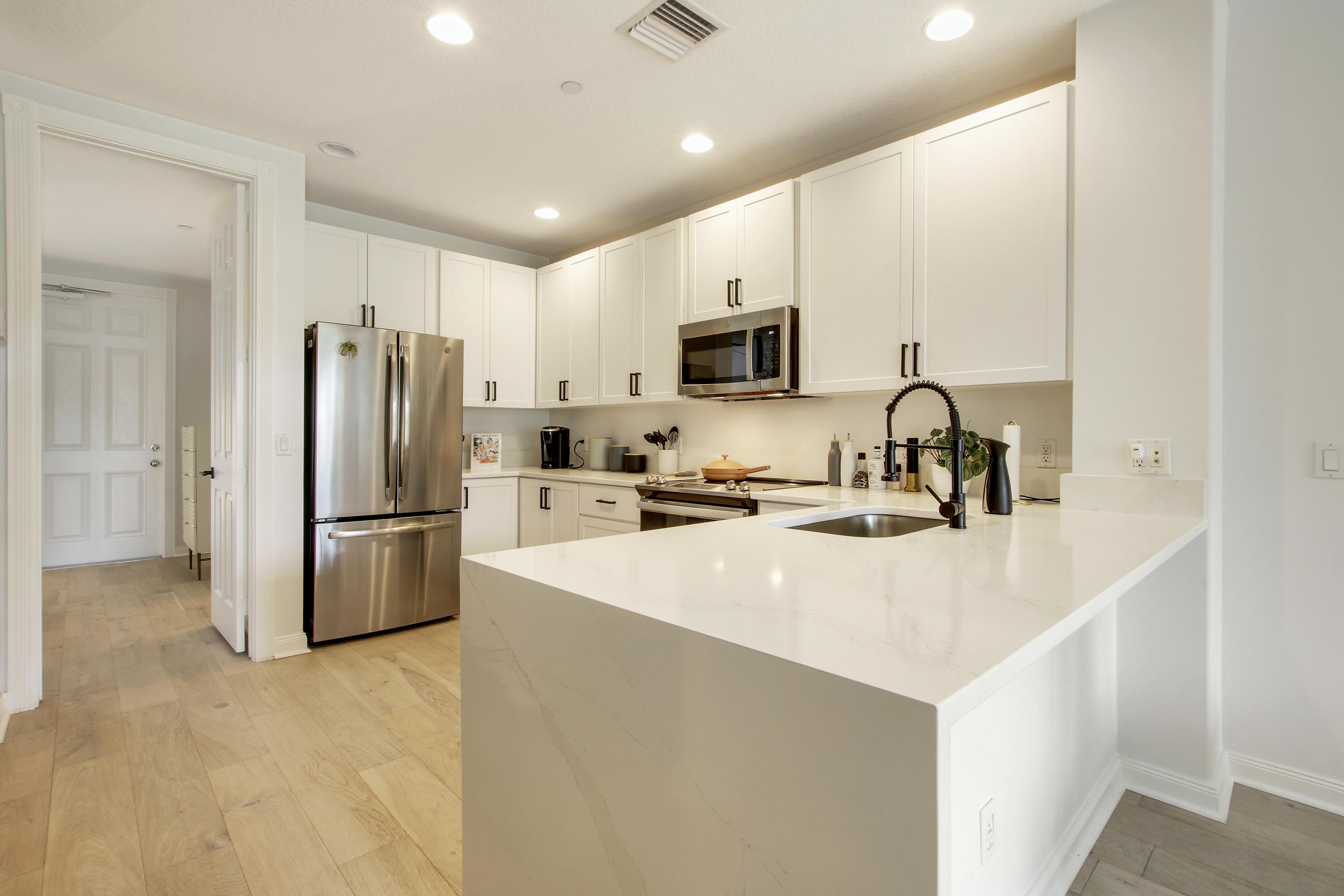 3424 West Community Drive Jupiter, FL 33458 - Photo 2 of 25 a kitchen with stainless steel appliances a refrigerator stove microwave and sink