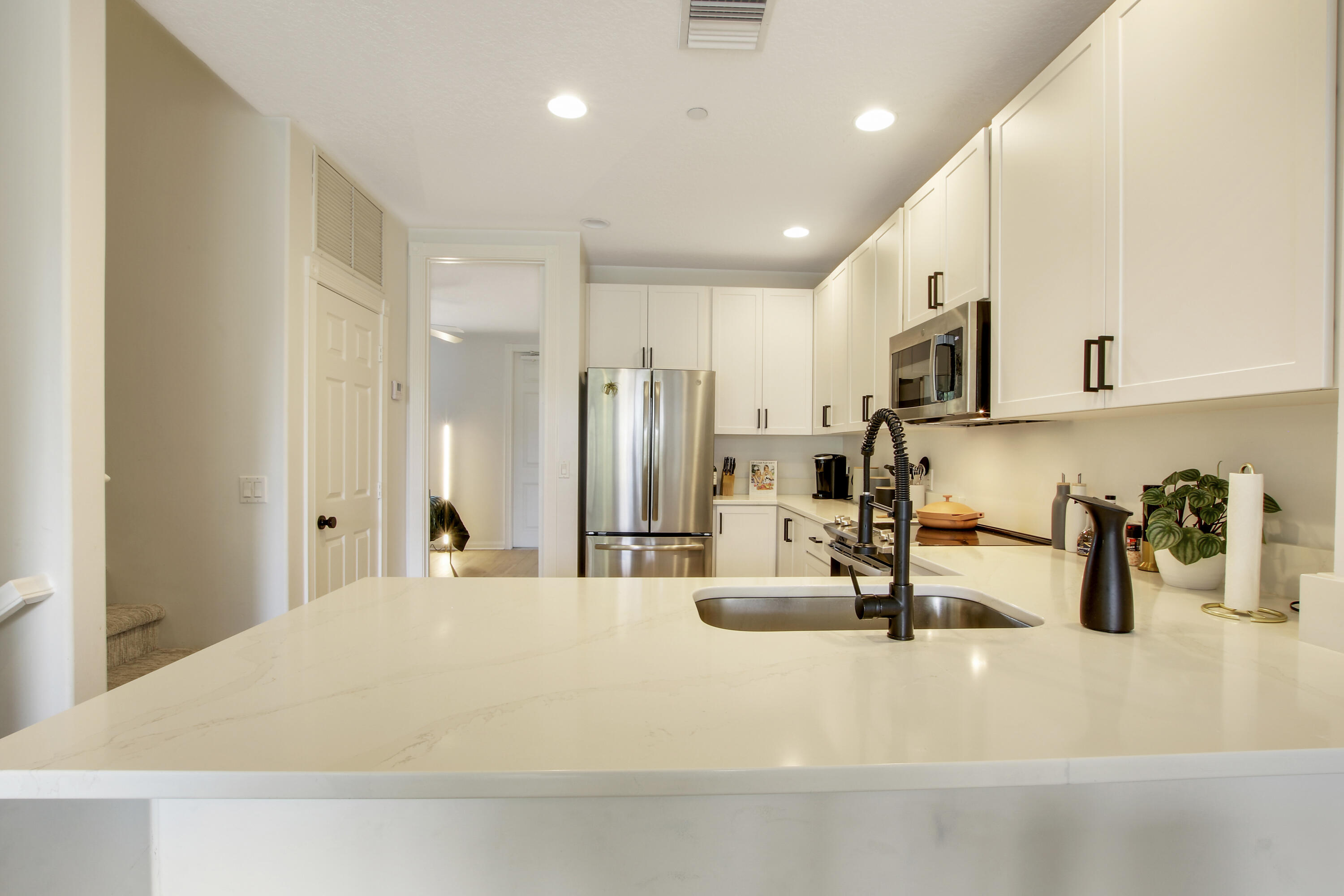 3424 West Community Drive Jupiter, FL 33458 - Photo 4 of 25 a kitchen with kitchen island a sink stainless steel appliances and cabinets