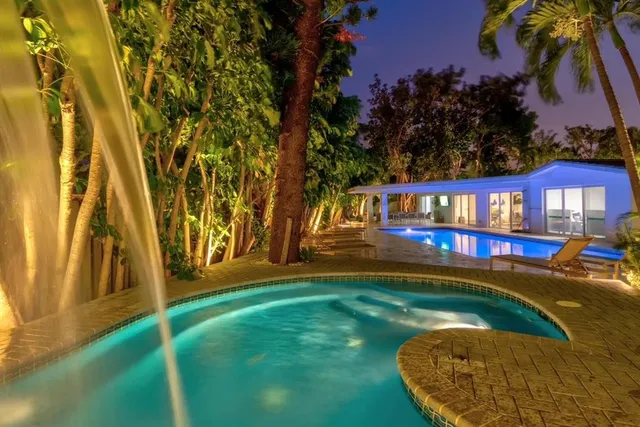 a view of swimming pool with outdoor seating and covered with trees