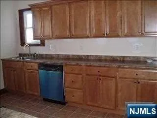 a kitchen with granite countertop a sink cabinets and stainless steel appliances