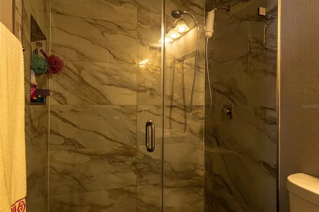a view of a backyard with table and chairs potted plants and large tree