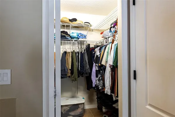 a view of walk in closet with clothes and shoes