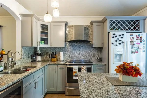 a kitchen with stainless steel appliances granite countertop a sink stove and refrigerator