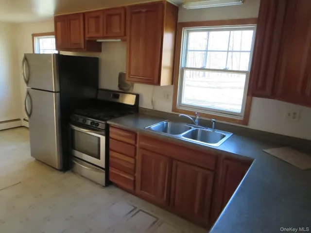 a kitchen with granite countertop a refrigerator and a sink