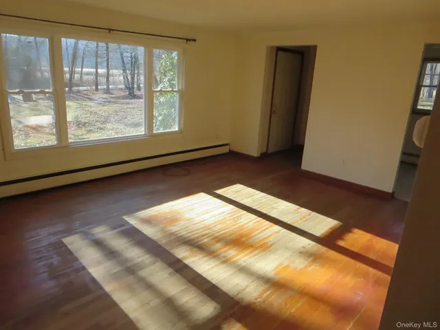 a view of empty room with wooden floor