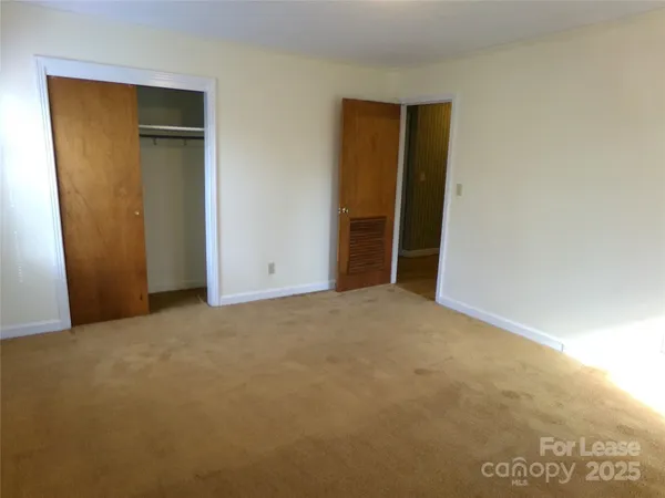 an empty room with closet and wooden floor