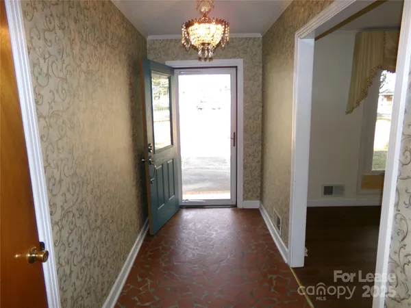 a view of a hallway with wooden floor and a dining room