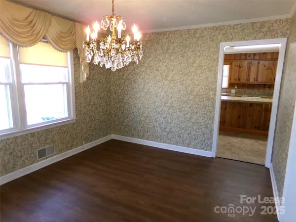a view of empty room with window and wooden floor