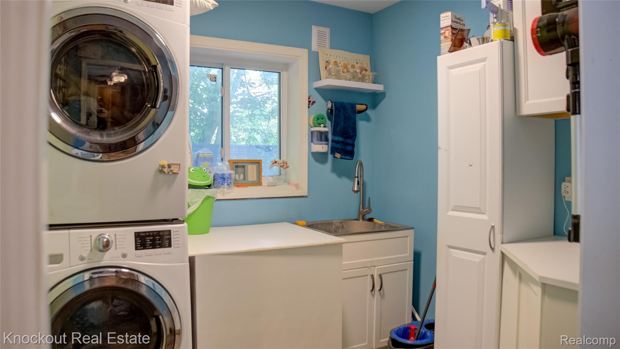 4195 Williamson Road Saginaw, MI 48601 - Photo 8 of 50 Dedicated laundry area featuring stacked front-load machines, a utility sink with a high-arc faucet, and a window providing natural light