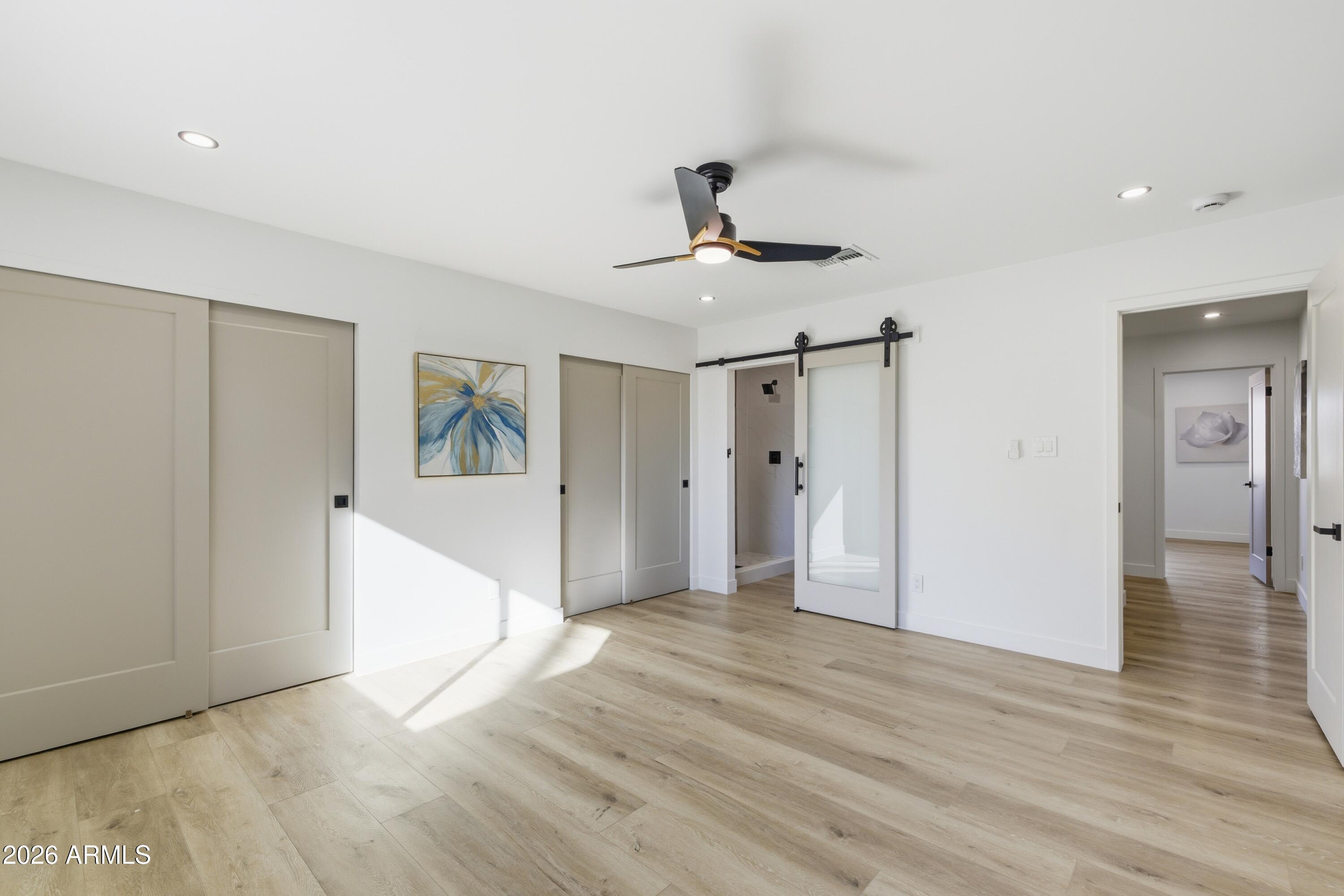7761 East Chaparral Road Scottsdale, AZ 85250 - Photo 12 of 36 a view of a hallway with wooden floor and a ceiling fan
