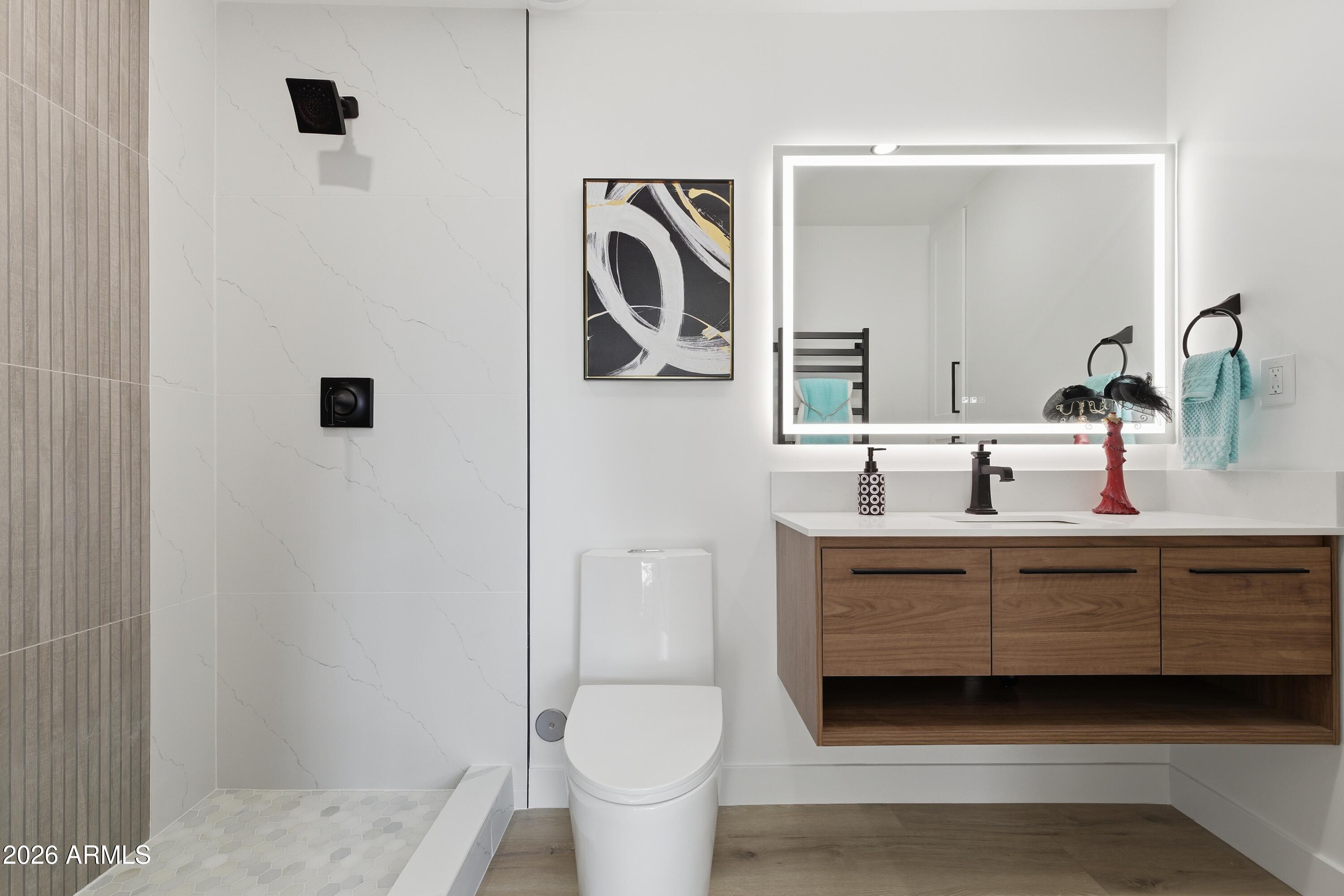 7761 East Chaparral Road Scottsdale, AZ 85250 - Photo 14 of 36 a bathroom with a toilet a sink and mirror