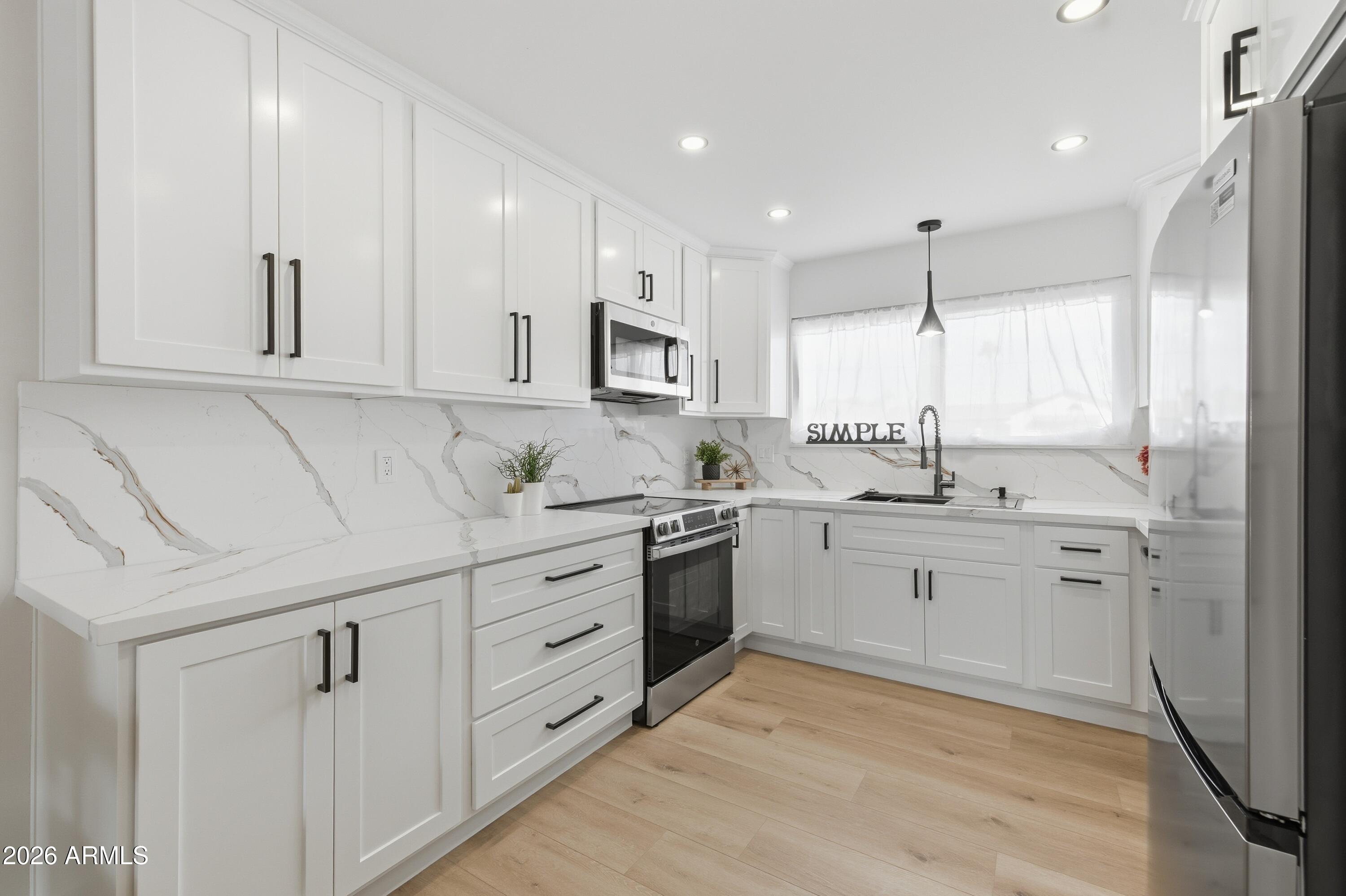 7761 East Chaparral Road Scottsdale, AZ 85250 - Photo 6 of 36 a kitchen with sink cabinets and window