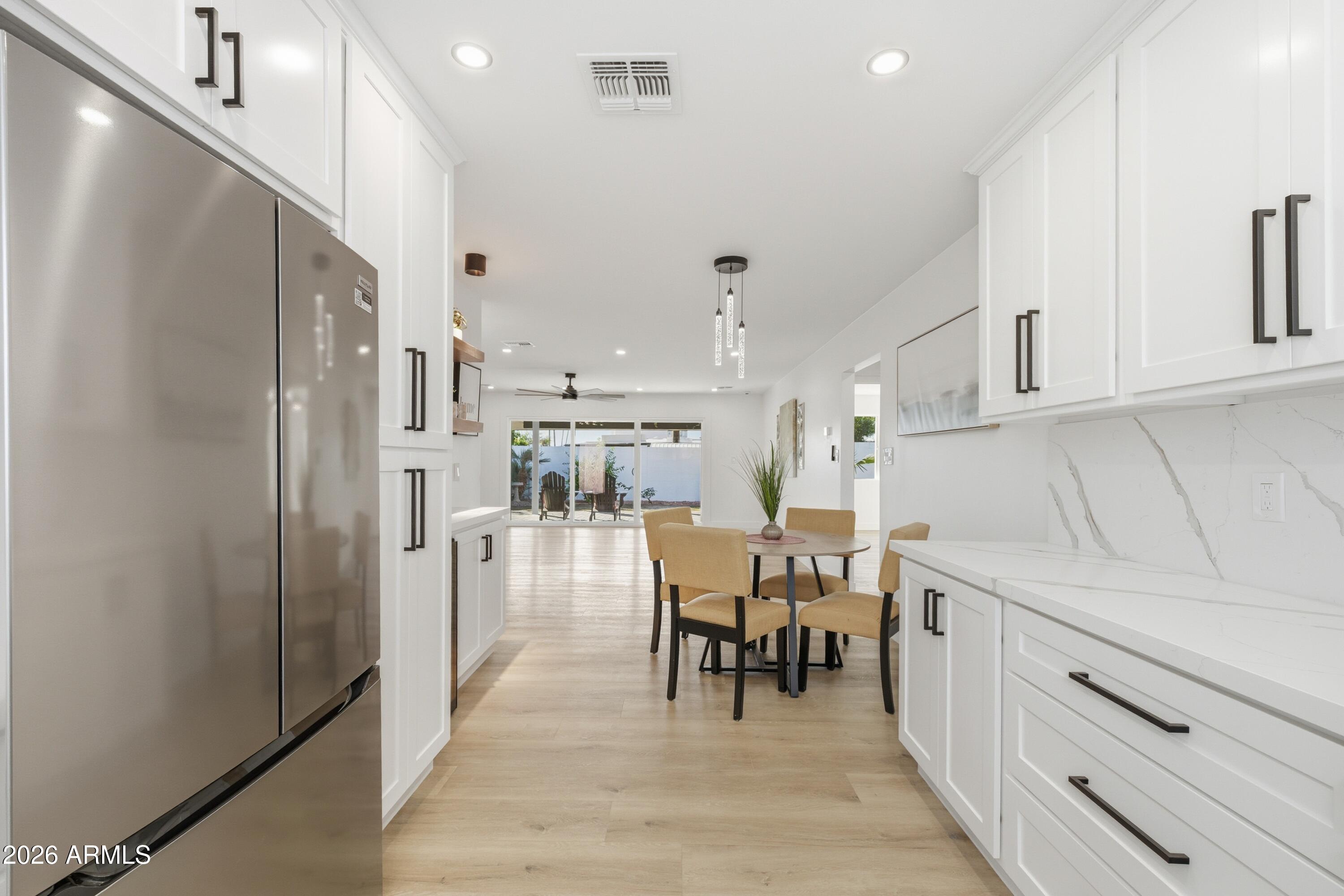 7761 East Chaparral Road Scottsdale, AZ 85250 - Photo 7 of 36 a kitchen with stainless steel appliances kitchen island granite countertop a refrigerator and cabinets