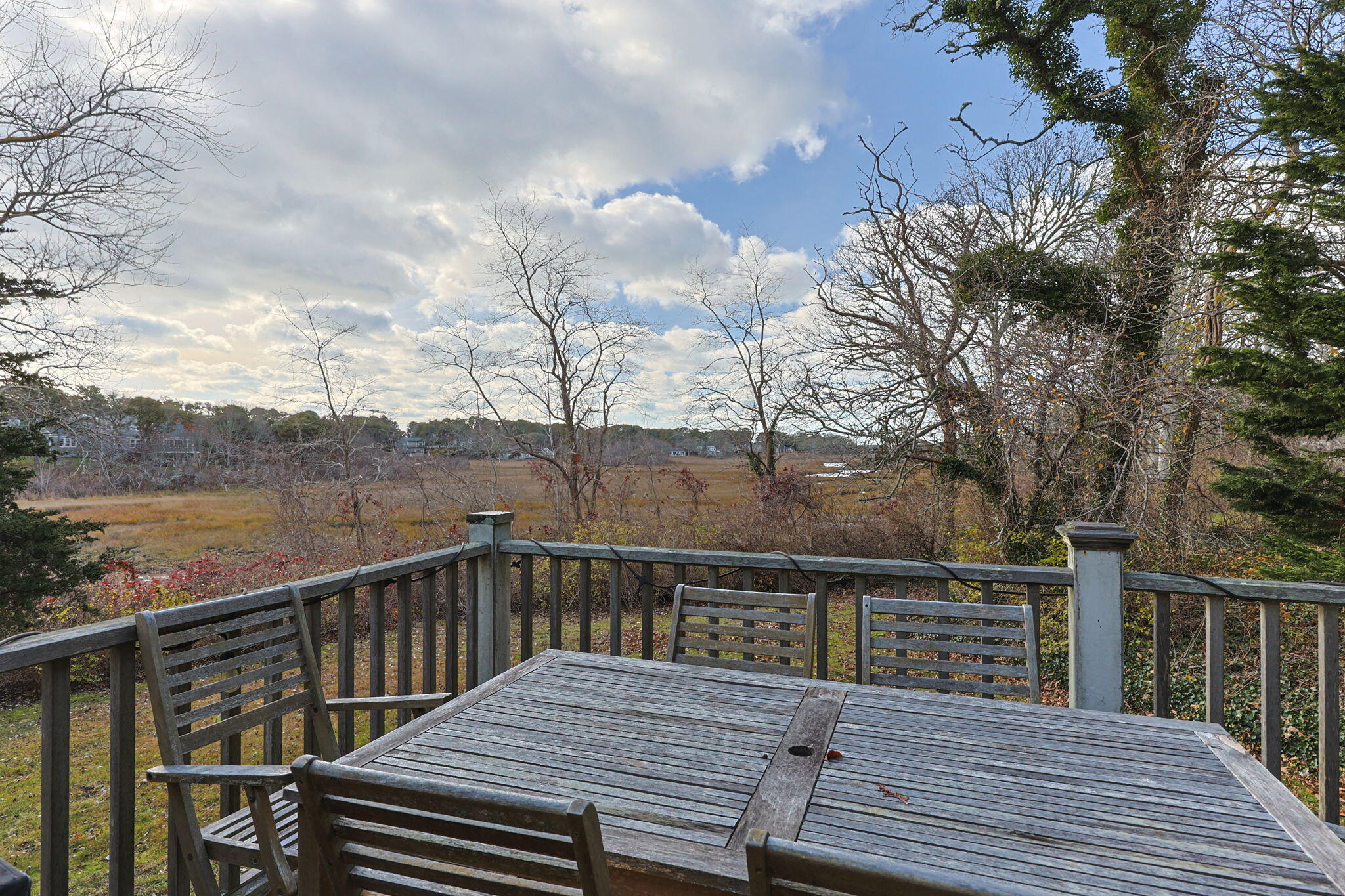 144 Barn Hill Road Chatham, MA 02633 - Photo 20 of 24 a view of a balcony with wooden chairs and floor to ceiling window