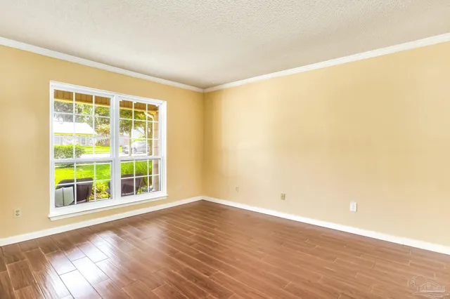 an empty room with wooden floor and chandelier