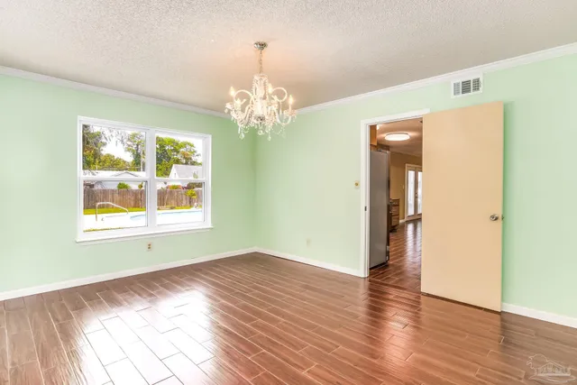 a view of a room with wooden floor and chandelier