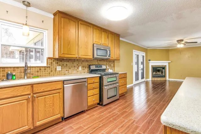 a view of a kitchen with wooden floor and a ceiling fan