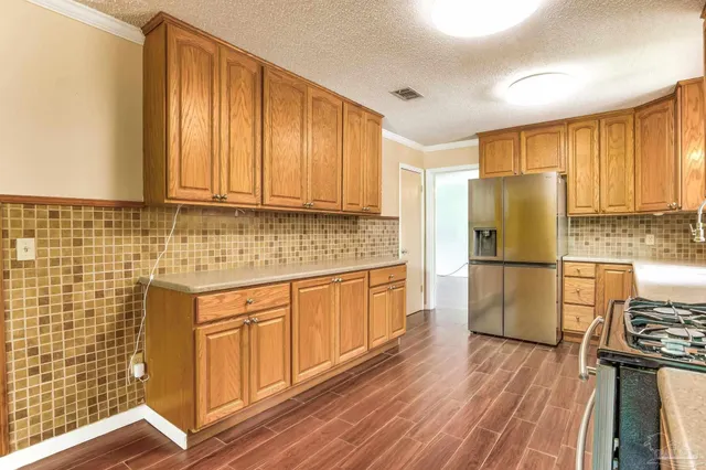 an empty room with ceiling fan and large windows