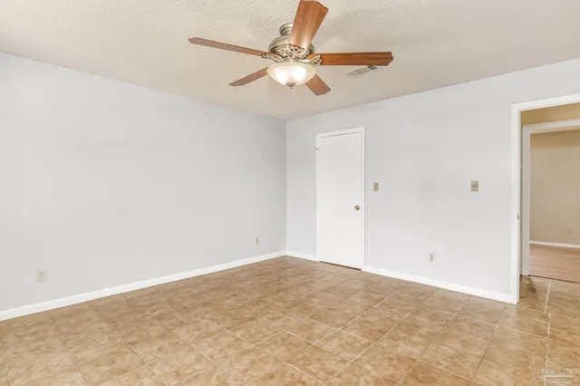 a big room with wooden floor staircase and windows