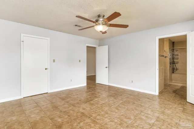 an empty room with wooden floor and a ceiling fan