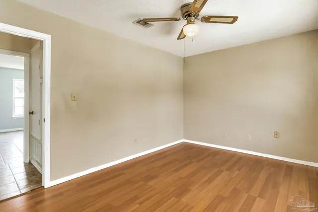 a view of swimming pool with seating area and trees in the background